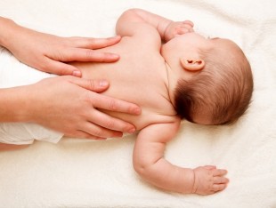 Masseuse massaging 5 months infant