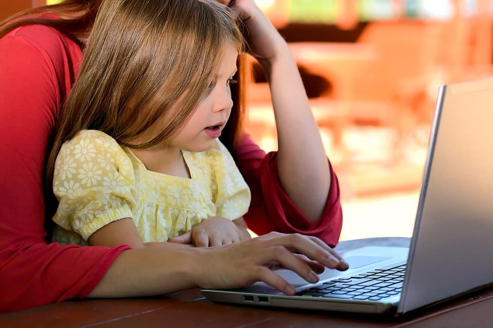 Criança usando um computador com a mãe. Criança usando um computador com a mãe.